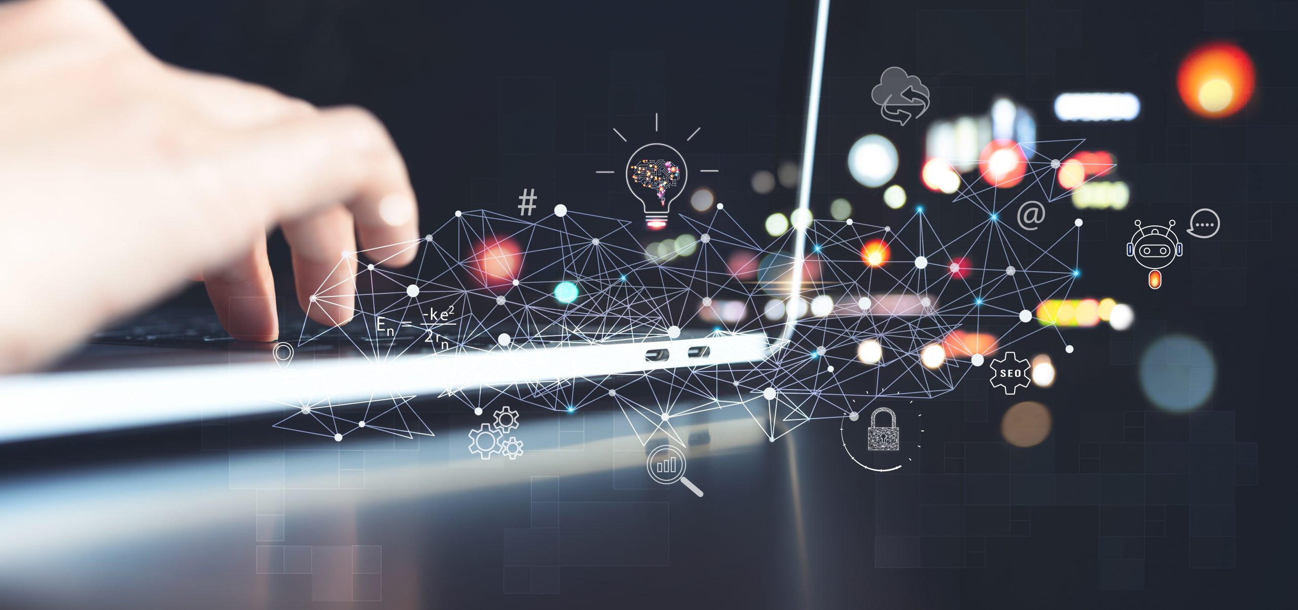 Three people working on computers in a dark room